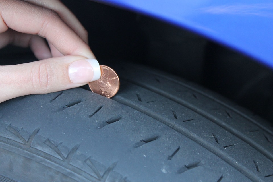 Testing a tire's tread depth with a penny.